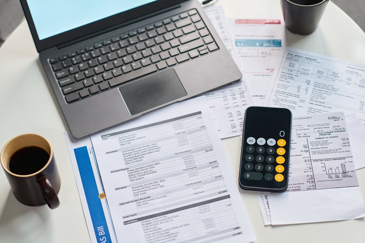 Financial documents and analytical tools on a desk representing the underwriting process